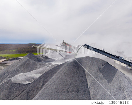 Granite quarry shows workers processing stone to create aggregate used in construction and road building 139046118