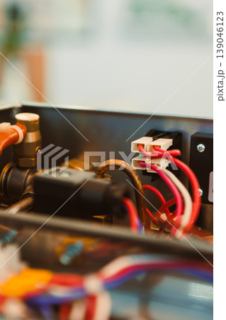 Close-up view of wires and connectors in an electronic device during assembly or maintenance in a workshop setting Close-up view of wires and connectors in an electronic device during assembly or maintenance in a workshop setting 139046123
