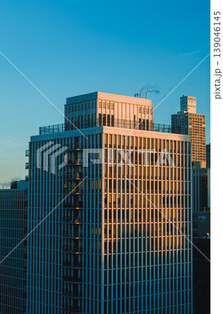 City skyline at sunset showing modern buildings and warm light reflecting off glass surfaces City skyline at sunset showing modern buildings and warm light reflecting off glass surfaces 139046145