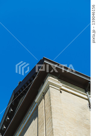 Looking up at the corner of a tall building with clear blue sky in the background on a sunny day Looking up at the corner of a tall building with clear blue sky in the background on a sunny day 139046156