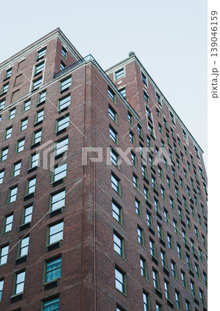 Building structure stands tall with many windows under clear sky in urban setting during daytime Building structure stands tall with many windows under clear sky in urban setting during daytime 139046159