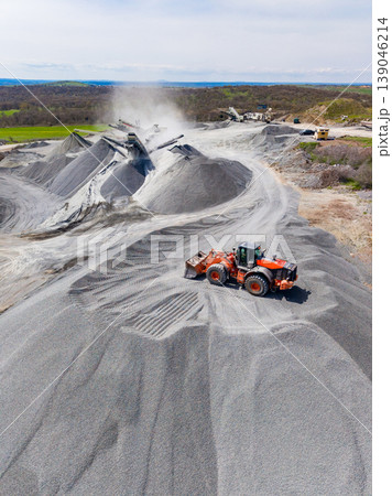 Granite quarry operation with machinery moving stone and processing materials during daylight Granite quarry operation with machinery moving stone and processing materials during daylight 139046214