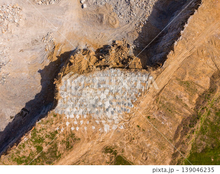 Granite quarry operation shows workers extracting stone at a large site in a rural area during daylight hours 139046235