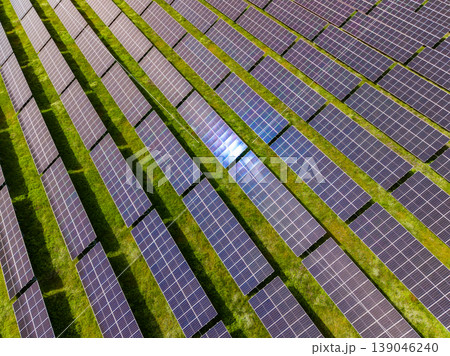 Large solar panel field located in a green area generating electricity during midday sunlight and capturing energy from the sun Large solar panel field located in a green area generating electricity during midday sunlight and capturing energy from the sun 139046240