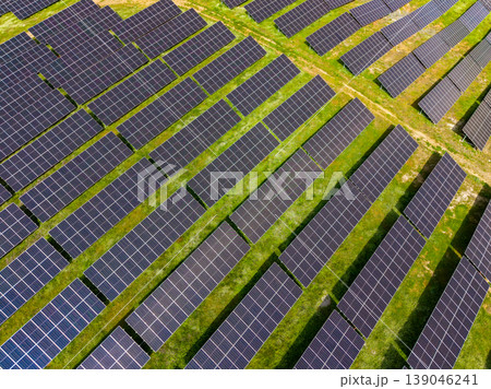Large solar farm with rows of solar panels in an open field during daytime Large solar farm with rows of solar panels in an open field during daytime 139046241