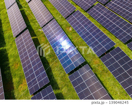 Rows of solar panels capture sunlight in a field during midday in an area designed for renewable energy production Rows of solar panels capture sunlight in a field during midday in an area designed for renewable energy production 139046245