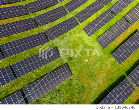 Rows of solar panels cover a green field in a renewable energy project in broad daylight showcasing clean power generation Rows of solar panels cover a green field in a renewable energy project in broad daylight showcasing clean power generation 139046246