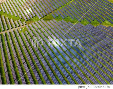 Solar panels cover large area in agricultural field showcasing renewable energy usage during bright daylight in a rural setting Solar panels cover large area in agricultural field showcasing renewable energy usage during bright daylight in a rural setting 139046270