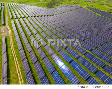 Large solar panel array in a rural area under clear blue sky during daytime with bright sunshine illuminating the landscape and panels Large solar panel array in a rural area under clear blue sky during daytime with bright sunshine illuminating the landscape and panels 139046282
