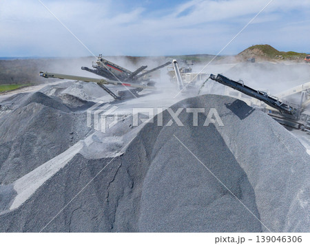 Granite quarry showing machinery and large piles of crushed stone during rock processing in daylight Granite quarry showing machinery and large piles of crushed stone during rock processing in daylight 139046306