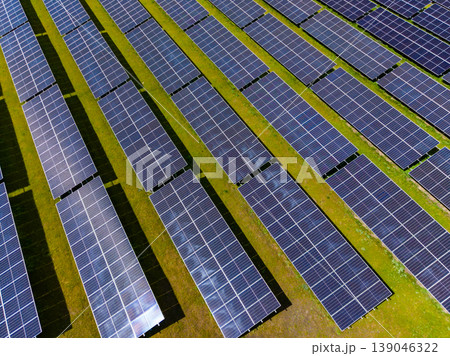 Solar panels cover a large field in a renewable energy site showing rows of panels under clear blue sky during daytime 139046322