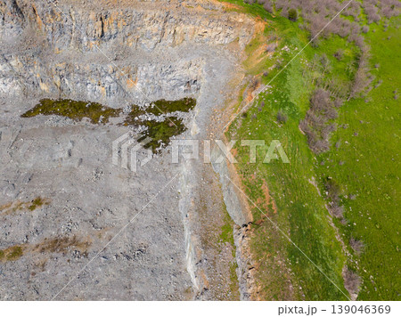 Granite quarry in a landscape showing stone extraction, vegetation nearby, and rock formations from above Granite quarry in a landscape showing stone extraction, vegetation nearby, and rock formations from above 139046369