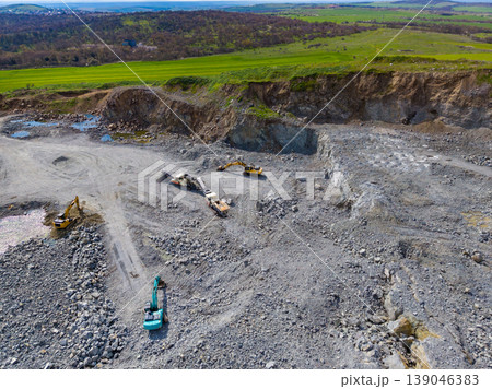Granite quarry operation showing machinery, equipment, and natural landscape during daylight in a rural area Granite quarry operation showing machinery, equipment, and natural landscape during daylight in a rural area 139046383