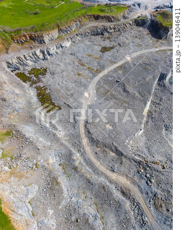 Granite quarry showing rock formations, paths, and equipment in an active mining area during daylight hours Granite quarry showing rock formations, paths, and equipment in an active mining area during daylight hours 139046411