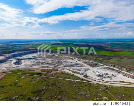 Granite quarry operation in a rural area with green fields and clear sky during the day Granite quarry operation in a rural area with green fields and clear sky during the day 139046421