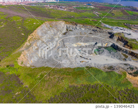 Granite quarry shows large excavation area with machinery and surrounding landscape in clear weather Granite quarry shows large excavation area with machinery and surrounding landscape in clear weather 139046425