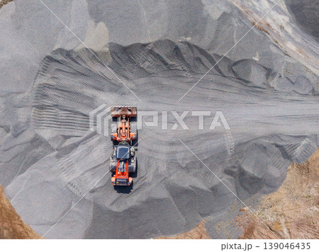 Granite quarry operation showing a loader moving gravel in an open area during daylight hours Granite quarry operation showing a loader moving gravel in an open area during daylight hours 139046435