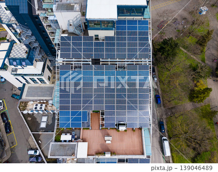 Buildings in urban area showcase solar panels on rooftops to harness clean energy and promote sustainability during the daytime Buildings in urban area showcase solar panels on rooftops to harness clean energy and promote sustainability during the daytime 139046489