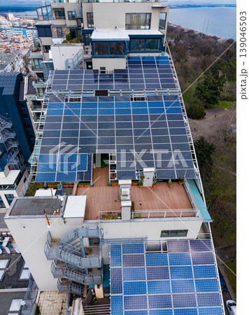 Solar panels on a modern building roof in a city near water during the day with clear skies and urban structures in view 139046503