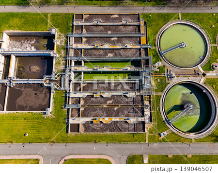 Water treatment facility operates with large tanks and processing equipment in an urban area during daylight hours 139046507
