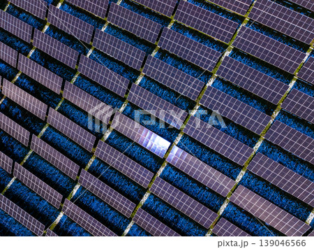 Rows of solar panels capture sunlight in an open field for energy generation during the day Rows of solar panels capture sunlight in an open field for energy generation during the day 139046566