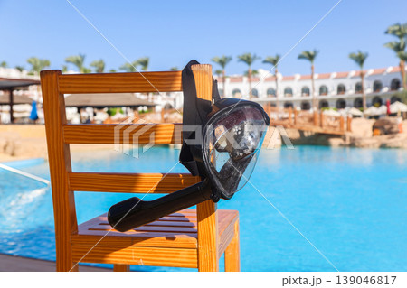 A black mask with a snorkel for scuba diving hangs on a lifeguard chair A black mask with a snorkel for scuba diving hangs on a lifeguard chair 139046817