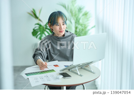 テーブルで仕事をする女性 139047054