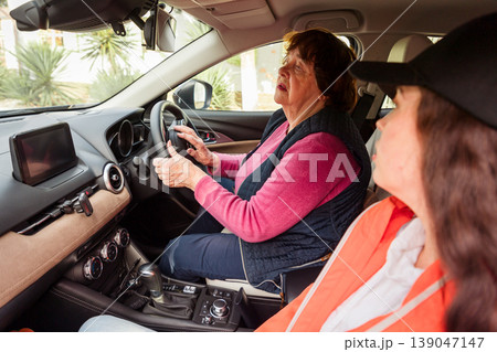 Mature Caucasian woman attends driving class with professional trainer. She improves coordination and attention. Concept of cognitive activity, education, and healthy aging. 139047147