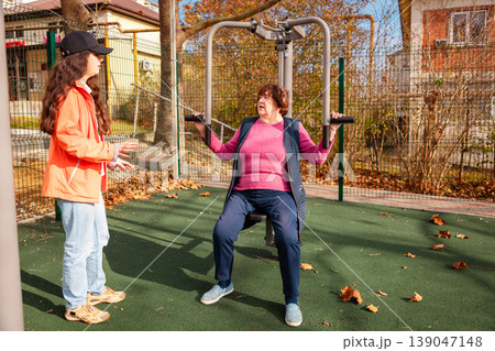 Older Caucasian woman follows a rehabilitation workout with a trainer. Sport and professional support improve recovery and independence. 139047148