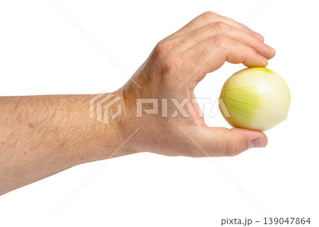 Fingers holding peeled onion bulb closeup 139047864