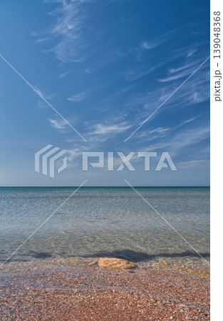 vertical poster with a view of a calm, warm sea from a shell beach, a high sky with wispy clouds, a concept for advertising a seaside vacation vertical poster with a view of a calm, warm sea from a shell beach, a high sky with wispy clouds, a concept for advertising a seaside vacation 139048368