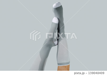 crossed legs upside down in compression socks 139048409