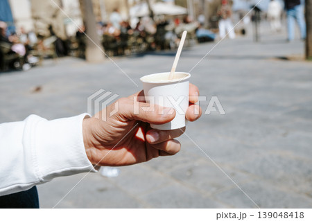 man with an espresso macchiato in a takeaway cup 139048418