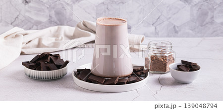 Warm cocoa drink in a glass and chocolate on a plate on the table web banner Warm cocoa drink in a glass and chocolate on a plate on the table web banner 139048794