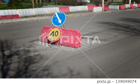 Road under repair with a traffic sign and barriers in a residential area 139049074