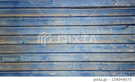Wooden surface painted blue with visible texture and grain during daylight hours Wooden surface painted blue with visible texture and grain during daylight hours 139049075