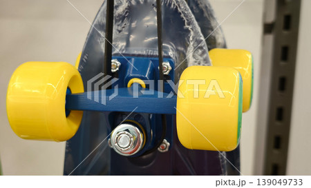 Bright yellow skateboard wheels and blue axle close up in a store setting Bright yellow skateboard wheels and blue axle close up in a store setting 139049733