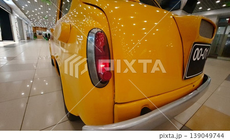 Bright yellow taxi car parked at a shopping mall during the day Bright yellow taxi car parked at a shopping mall during the day 139049744
