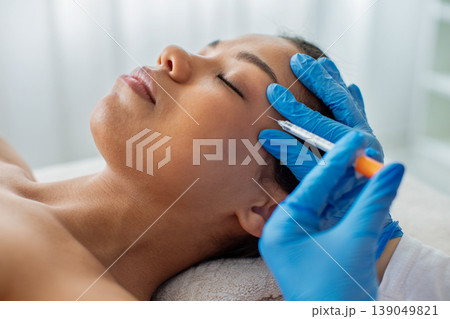 Closeup of young African American woman receiving facial injection treatment in clinic 139049821
