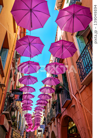 Pink umbrellas hanging in the streets of Collioure in France. Pink umbrellas hanging in the streets of Collioure in France. 139049894