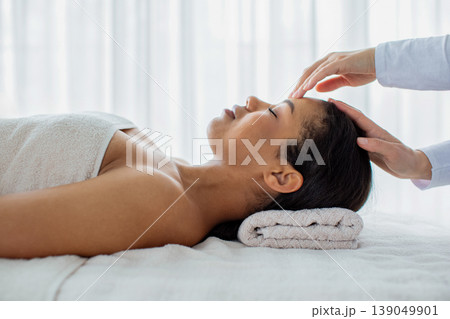 Young African American woman receiving relaxing head massage at spa Young African American woman receiving relaxing head massage at spa 139049901
