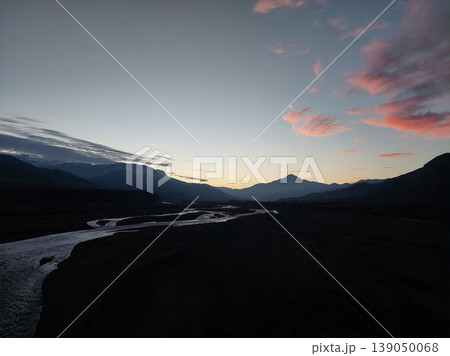 Panoramic view of a winding mountain river at sunset with pink clouds in the sky. Panoramic view of a winding mountain river at sunset with pink clouds in the sky. 139050068