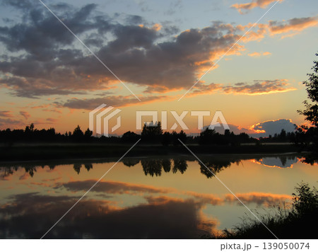 Beautiful sunset over a calm river with perfect sky reflection in the water. 139050074