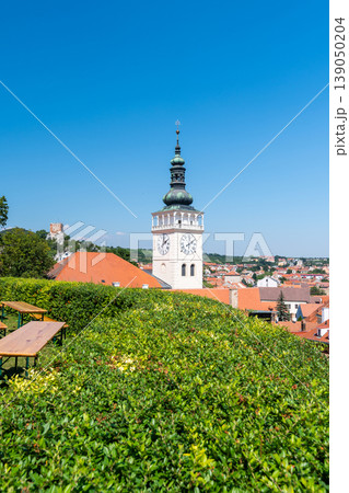 Aerial panorama of Mikulov city, czech republic. The tower of St Wenceslas in foreground. "Svaty kopec" hill with St Sebastian chapel in background. Look to town roofs, summer day. Aerial panorama of Mikulov city, czech republic. The tower of St Wenceslas in foreground. "Svaty kopec" hill with St Sebastian chapel in background. Look to town roofs, summer day. 139050204