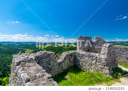 The old ruins of castle Cachtice (Cachtice in local speak). Ruined castle on top of hill at Slovakia. Famous and mysterious place known from legend of blood lady Bathory. Summer day, panorama view. The old ruins of castle Cachtice (Cachtice in local speak). Ruined castle on top of hill at Slovakia. Famous and mysterious place known from legend of blood lady Bathory. Summer day, panorama view. 139050281