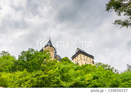 Famous medieval gothic castle Karlstejn on top of the hill. Beautiful stronghold is built by king Charles IV. Historical national heritage of Czech Republic is placed near Prague city. Cloudy weather Famous medieval gothic castle Karlstejn on top of the hill. Beautiful stronghold is built by king Charles IV. Historical national heritage of Czech Republic is placed near Prague city. Cloudy weather 139050337