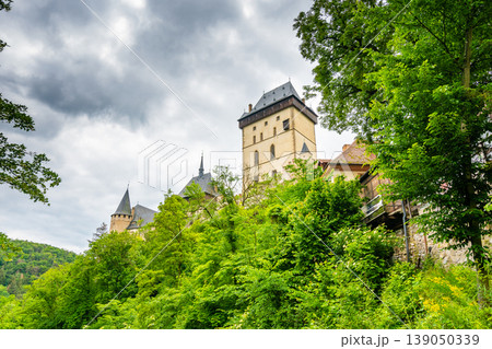 Famous medieval gothic castle Karlstejn on top of the hill. Beautiful stronghold is built by king Charles IV. Historical national heritage of Czech Republic is placed near Prague city. Cloudy weather 139050339
