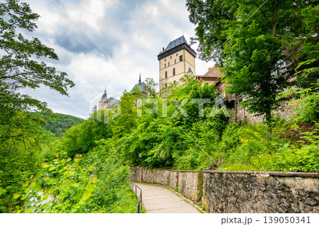 Famous medieval gothic castle Karlstejn on top of the hill. Beautiful stronghold is built by king Charles IV. Historical national heritage of Czech Republic is placed near Prague city. Cloudy weather Famous medieval gothic castle Karlstejn on top of the hill. Beautiful stronghold is built by king Charles IV. Historical national heritage of Czech Republic is placed near Prague city. Cloudy weather 139050341