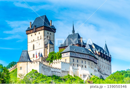 View of the famous Karlstejn castle, Czech republic. Castle built in gothic style by king and emperor of Roman rise, Charles IV. Czech historic heritage, beautiful summer day. View of the famous Karlstejn castle, Czech republic. Castle built in gothic style by king and emperor of Roman rise, Charles IV. Czech historic heritage, beautiful summer day. 139050346