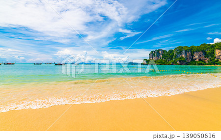 Beautiful view of long tail boats on water in Railay beach bay, Thailand, Krabi town. Famous tourist destination for vacation in tropical paradise. Beautiful summer day. Big limestone hill and rock 139050616